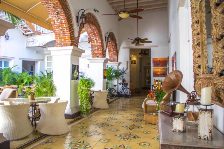 Lobby colonial con arcos de ladrillo, gramófono vintage y suelo hidráulico del Hotel Boutique Don Pepe
