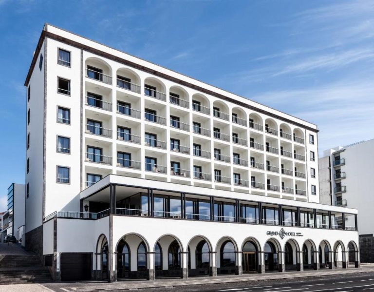 Fachada exterior del Grand Hotel Açores Atlântico con arcos blancos y balcones en las Azores