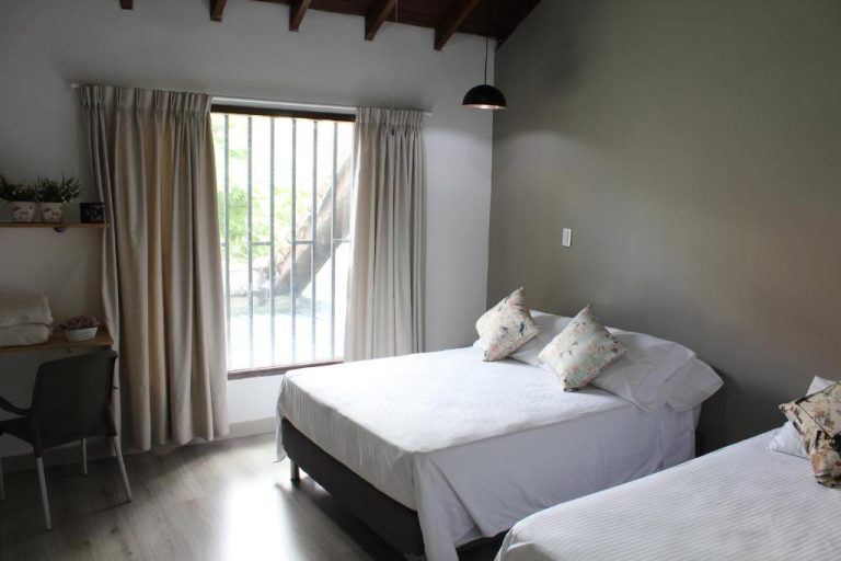 Habitación doble con dos camas y ventana con jardín en Hotel Boutique Plaza