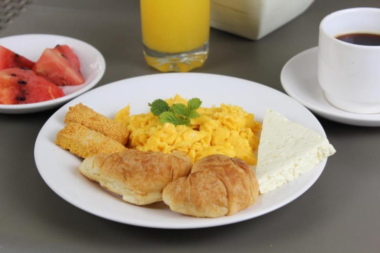 Desayuno completo con huevos revueltos, croissants y fruta en el Hotel Boutique Plaza
