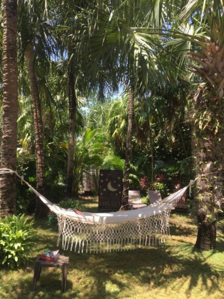 Hamaca de macramé en jardín tropical con palmeras del Hotel Lunata en la 5ª Avenida de Playa del Carmen