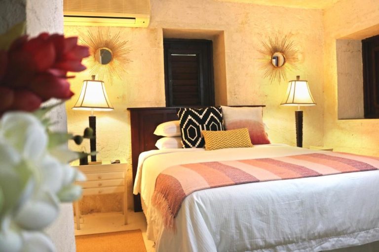 Habitación doble con cama king y decoración bohemia cálida en Sweetfield Manor Barbados