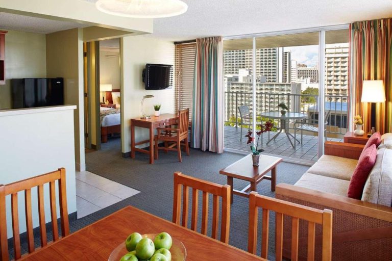Suite con salón comedor, cocina y balcón con vistas a la ciudad en el Pacific Monarch Hotel