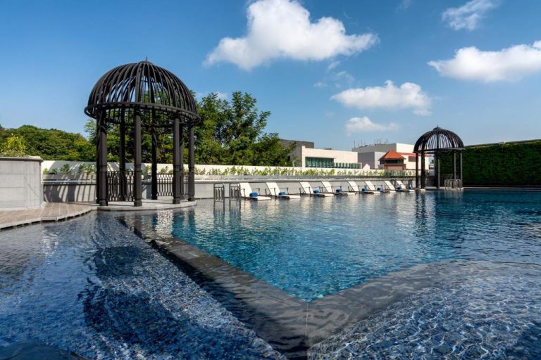 Piscina exterior con gazebos decorativos y tumbonas del Grand Park City Hall en Singapur
