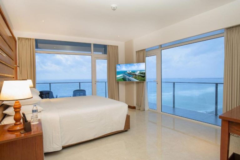 Habitación con cama doble y amplia terraza con vistas al océano en Marino Beach Colombo