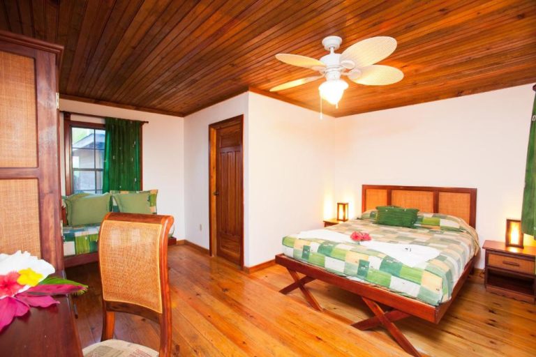 Habitación doble con suelo y techo de madera tropical en Las Rocas Resort and Dive Center