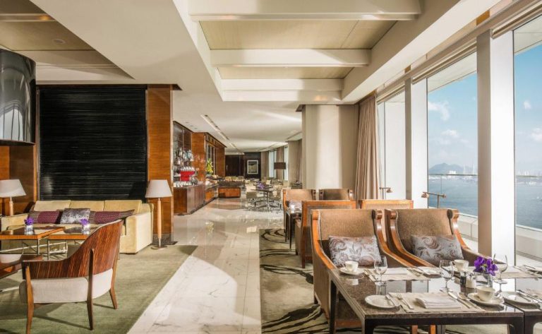 Elegante club lounge con vistas al mar y zona de comedor del Four Seasons Hotel Hong Kong