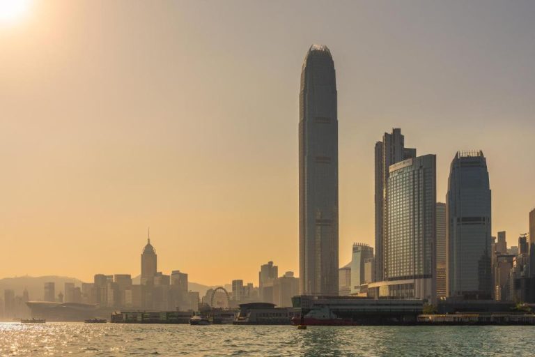 Vista del Four Seasons Hotel Hong Kong frente al Victoria Harbour al atardecer con el skyline de la ciudad