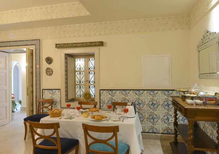 Sala de desayuno con decoración árabe y azulejos tradicionales en el Dar Alouini