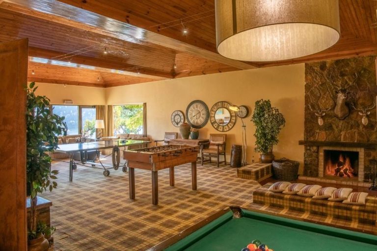 Sala de juegos con billar, futbolín y chimenea de piedra en el Lago Azul Eco Hotel