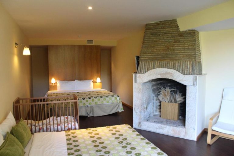 Habitación familiar con chimenea de piedra, cama doble y cuna en Hotel Da Montanha