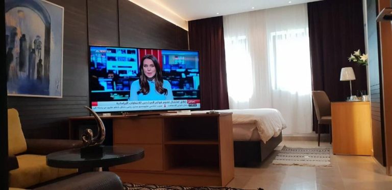 Habitación moderna con televisión de pantalla plana y cama en Hotel Ksar Dhiafa by Plaza Hotels