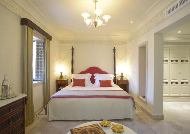 Habitación doble de lujo con cama con dosel y decoración árabe en Dar Alouini