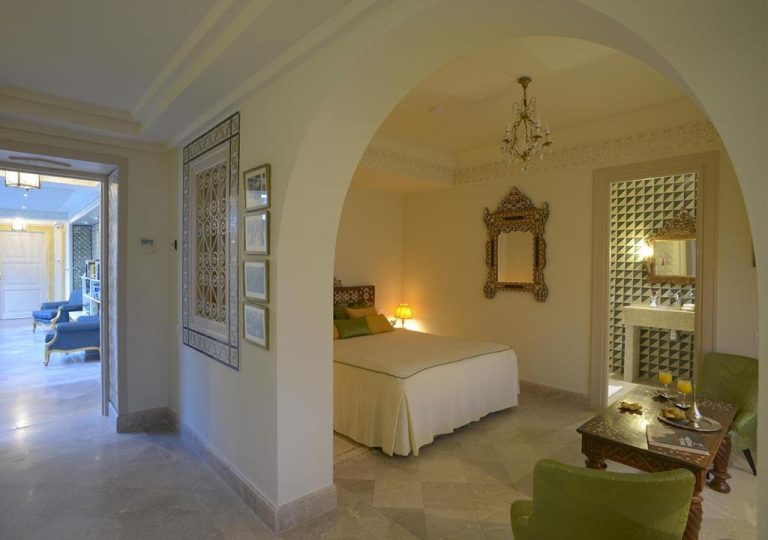 Habitación de lujo con arco árabe, cama doble y decoración oriental en Dar Alouini