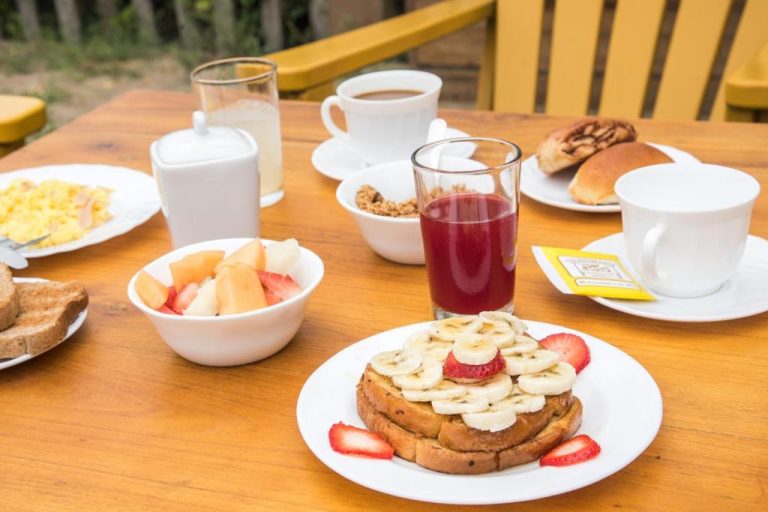 Desayuno completo con tostadas, frutas, zumos y café en la terraza del Hotel Kundalini