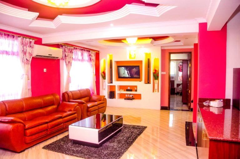 Lujosa sala de estar con sofás de cuero rojo y TV en el Sheratton Regency Hotel