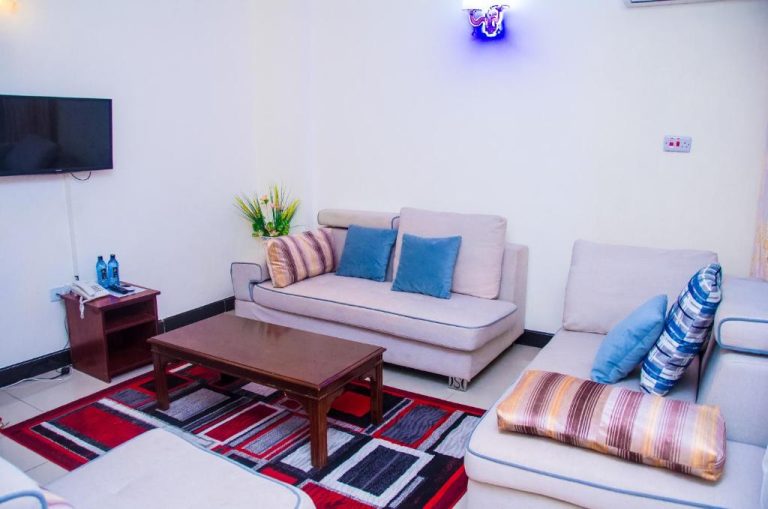 Sala de estar con sofás blancos y cojines azules en el Sheratton Regency Hotel
