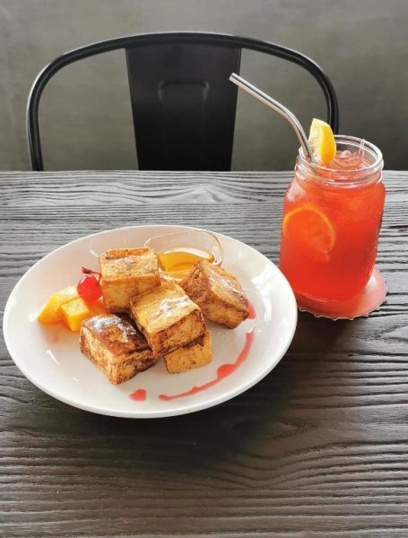 French toast con frutas y miel acompañado de bebida fría en el restaurante del Hotel GQ Plaza