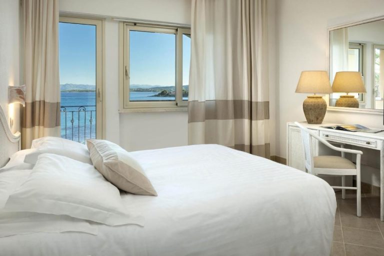 Habitación doble con cama blanca y vistas al mar en Gabbiano Azzurro Hotel & Suites