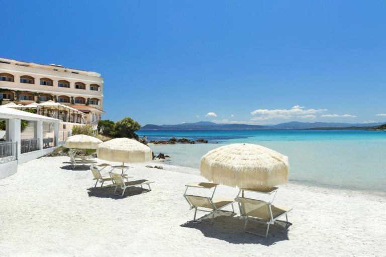 Playa privada con sombrillas y tumbonas del Gabbiano Azzurro Hotel & Suites en Cerdeña