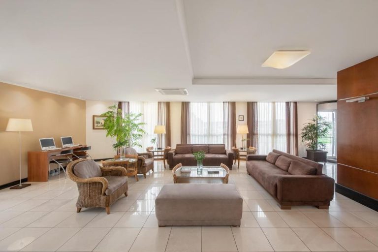 Amplio lobby con sofás de cuero y sillones de mimbre en el Hotel Intercity Florianopolis