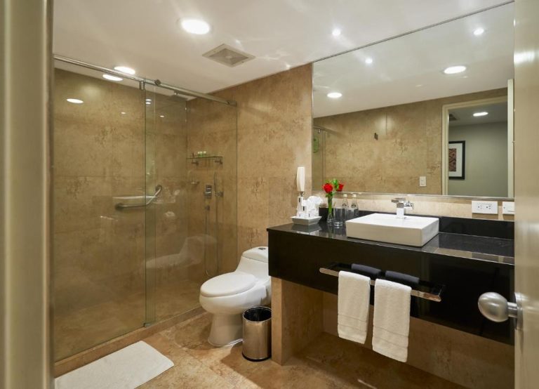 Baño moderno con ducha de cristal y lavabo en encimera del Hotel Oro Verde Guayaquil