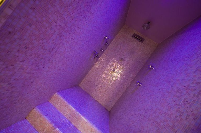 Sala de hammam con mosaicos y iluminación violeta en el spa del Relais dell'Olmo