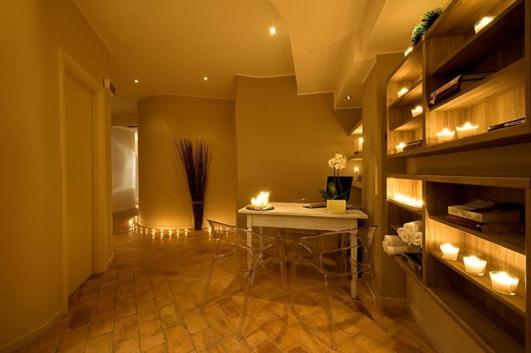 Zona de spa con iluminación de velas y estantería decorativa en el Relais dell'Olmo