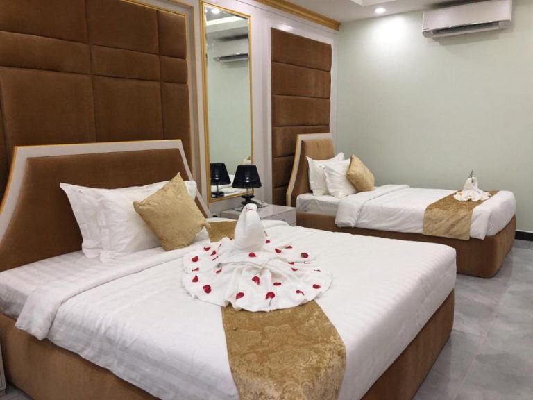 Habitación doble con camas decoradas con flores y toallas en Kampong Thom Royal Hotel