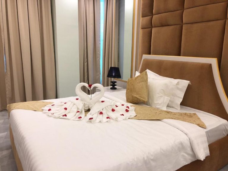 Habitación romántica con decoración de cisnes en toallas y pétalos de rosa en Kampong Thom Royal Hotel