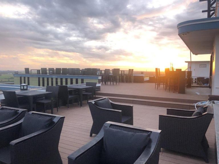 Terraza rooftop con mesas y sillas del Kampong Thom Royal Hotel con vistas al atardecer