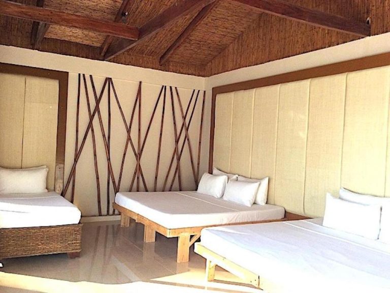 Habitación familiar con camas múltiples, decoración de bambú y techo de madera en Kaiyana Boracay Beach Resort