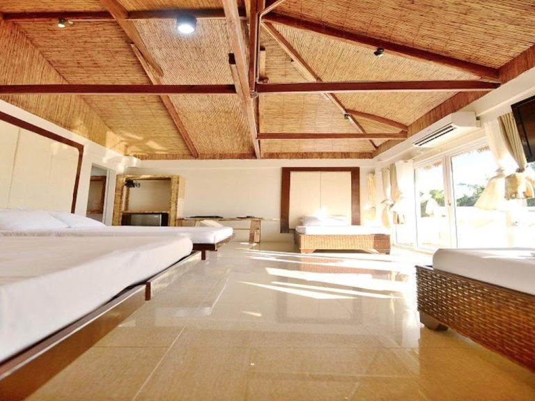 Amplia habitación con techo de bambú y múltiples camas en Kaiyana Boracay Beach Resort