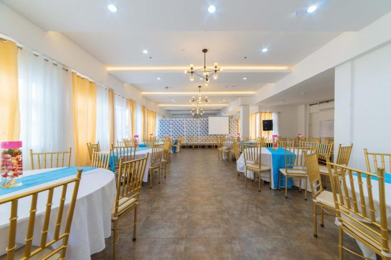 Salón de eventos con mesas redondas y sillas doradas en RedDoorz Plus Hotel Metro Kalibo
