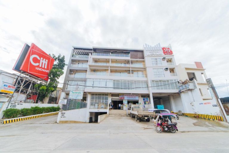 Fachada exterior del RedDoorz Plus at Hotel Metro Kalibo con entrada principal y estacionamiento