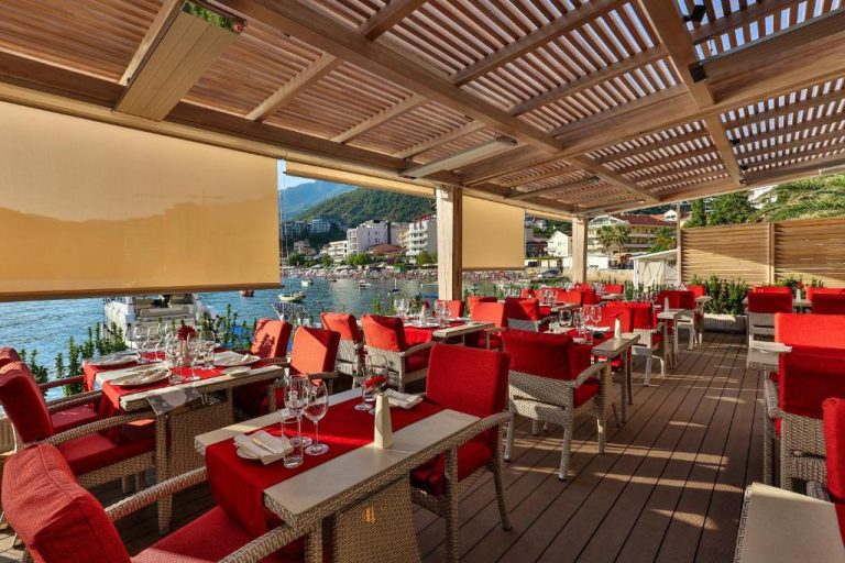 Terraza restaurante del Hotel Zeta con mesas en rojo y vistas al mar y la bahía