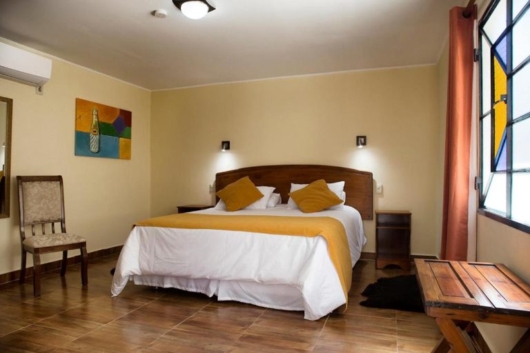 Habitación doble con cama matrimonial y decoración acogedora en Hotel FK Paso de los Toros Boutique
