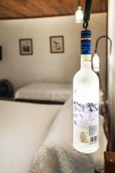 Lámpara decorativa hecha con botella de Grey Goose en habitación del Costa Verde Inn