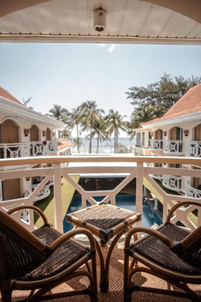 Balcón con sillas de ratán y vista a la piscina y playa del Boracay Mandarin Island Hotel