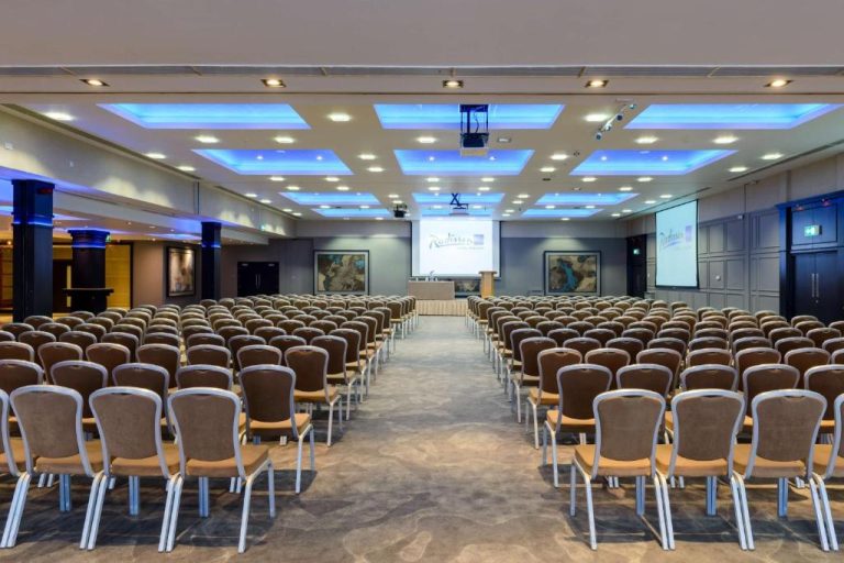 Amplia sala de conferencias con sillas y pantalla de proyección en el Radisson Blu Hotel Athlone