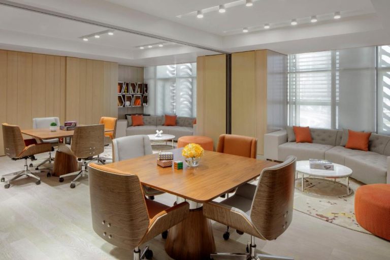 Sala de reuniones moderna con mesas de madera y sofás grises en el Paramount Hotel Dubai