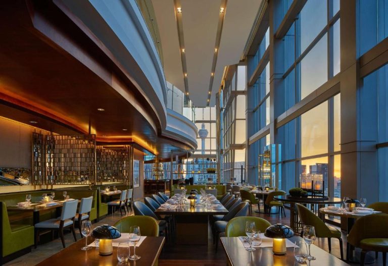 Elegante restaurante del Grand Hyatt Kuala Lumpur con vistas panorámicas a la torre KL Tower al atardecer