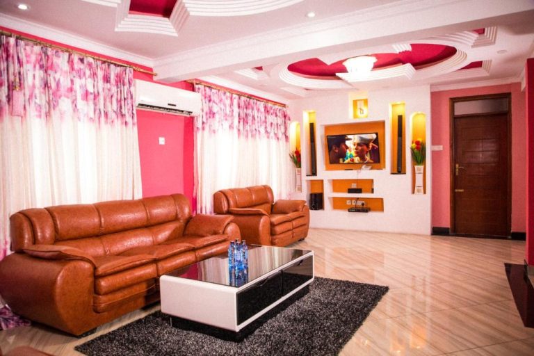 Amplio salón con sofás de cuero marrón y televisor empotrado del Sheratton Regency Hotel