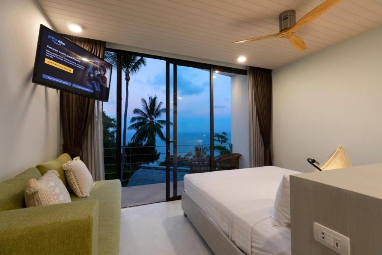 Habitación con cama doble, sofá y vistas al mar con palmeras en Kapuhala Koh Samui Vegan Boutique Hotel
