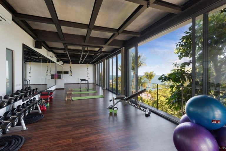 Gimnasio moderno con vistas al mar y palmeras en Kapuhala Koh Samui Vegan Boutique Hotel