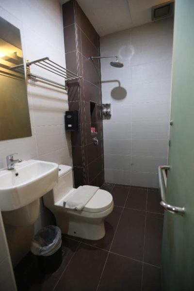 Baño completo con ducha de lluvia, lavabo y WC en el Kota Heritage Hotel