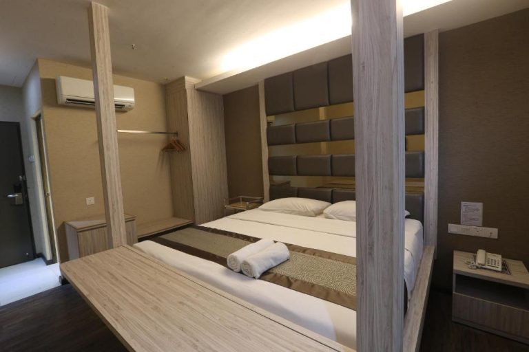 Habitación doble con elegante cabecero tapizado y cama king size en Kota Heritage Hotel