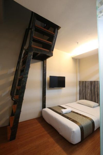 Habitación dúplex con escalera de metal y cama doble en Kota Heritage Hotel