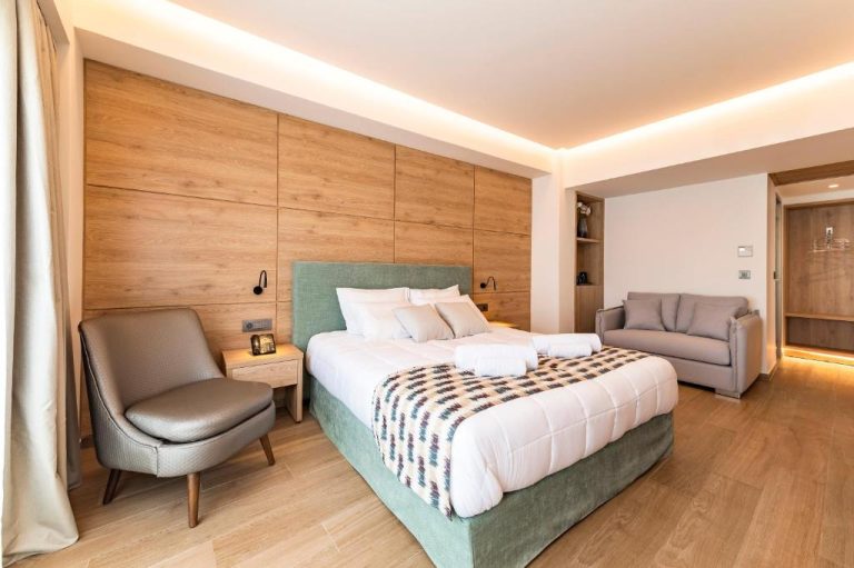 Habitación doble superior con cama king size y pared de madera en Acandia Hotel