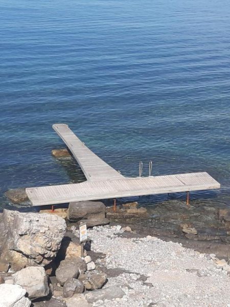 Embarcadero de madera con escalera de acceso al mar cristalino en Marettimo Residence